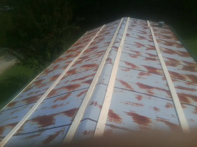 Rusted metal roof panels with new wood purlins before replacement — Storm Damage Roof Repair in Keysville by Roofing Brothers