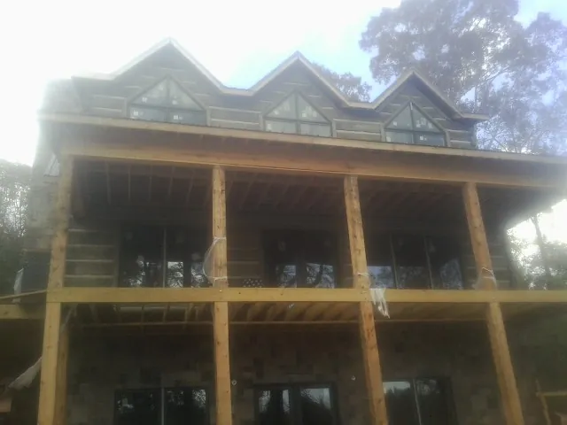 Dormers and porch framing on a large log home under construction — Roof Coating work by our crew in Keysville