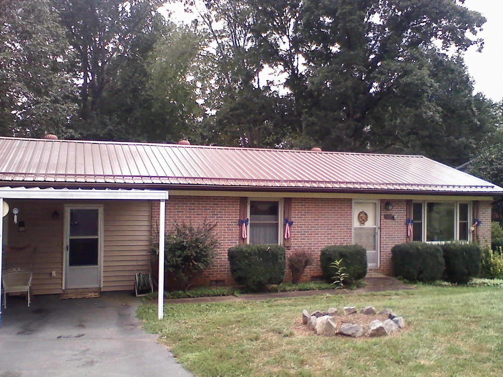 Bronze metal roof and carport on a brick ranch home — Roof Repair work by our crew in Keysville